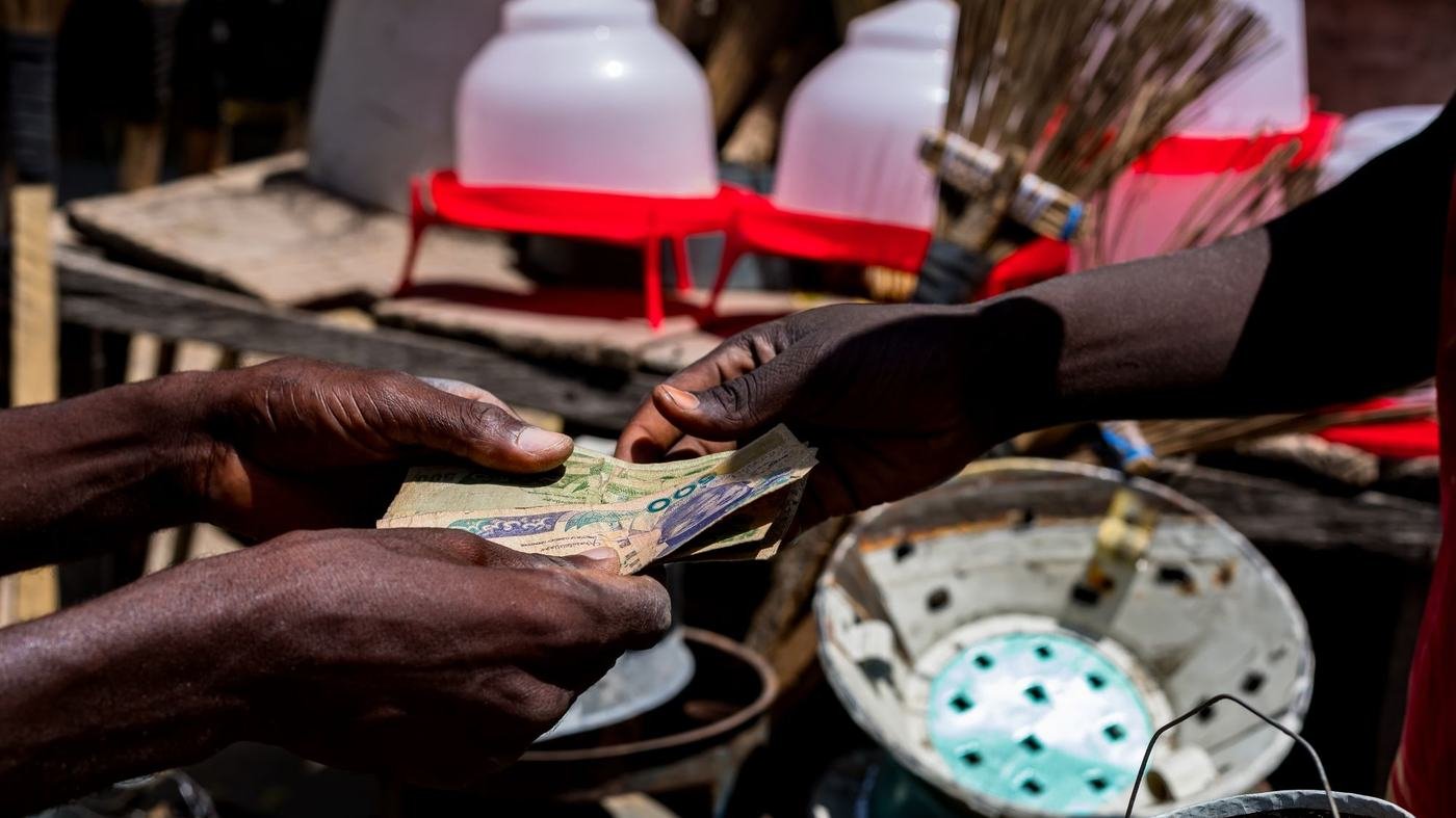 Échange de billets sur un étal de marché